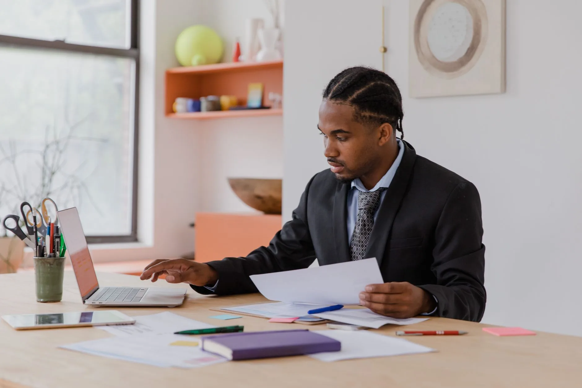 Dirigeant de petite entreprise organisant ses documents administratifs à son bureau